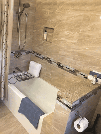 Modern bathroom featuring a bathtub, shower, and elegant stone tile design.