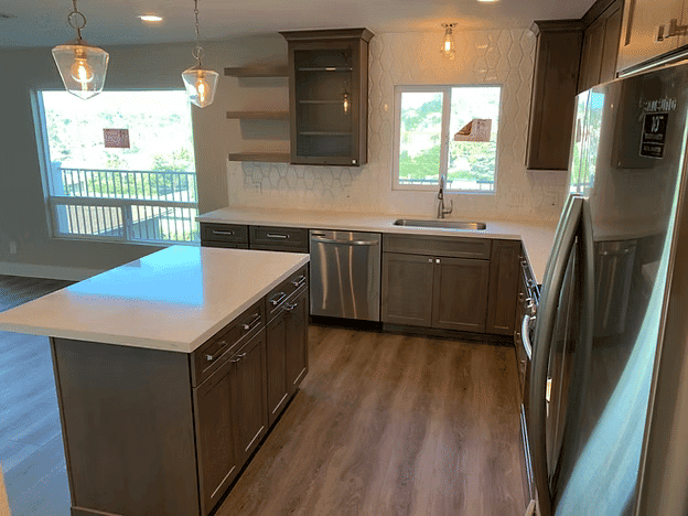 Modern kitchen with dark wood cabinets, stainless steel appliances, and a large island.