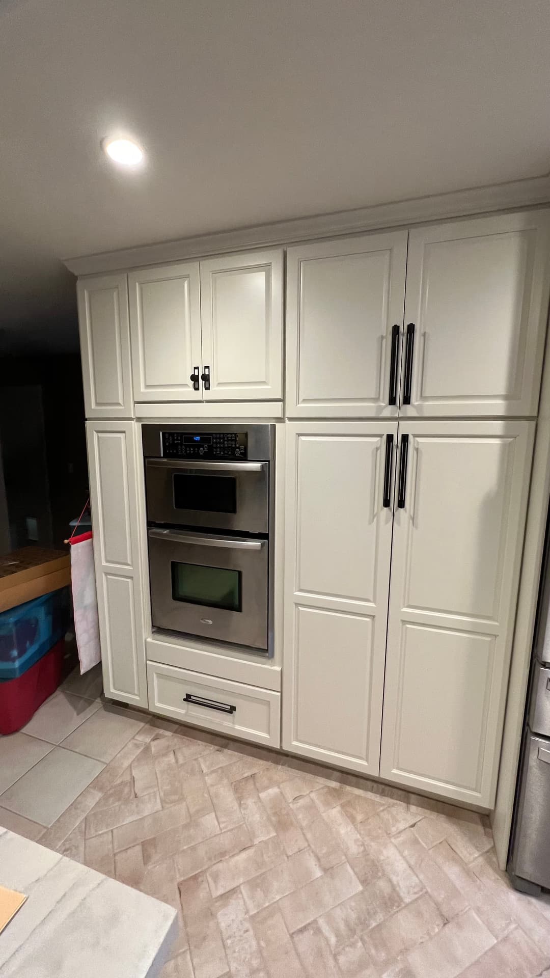 Modern kitchen with cream cabinets, built-in oven, and sleek black hardware.